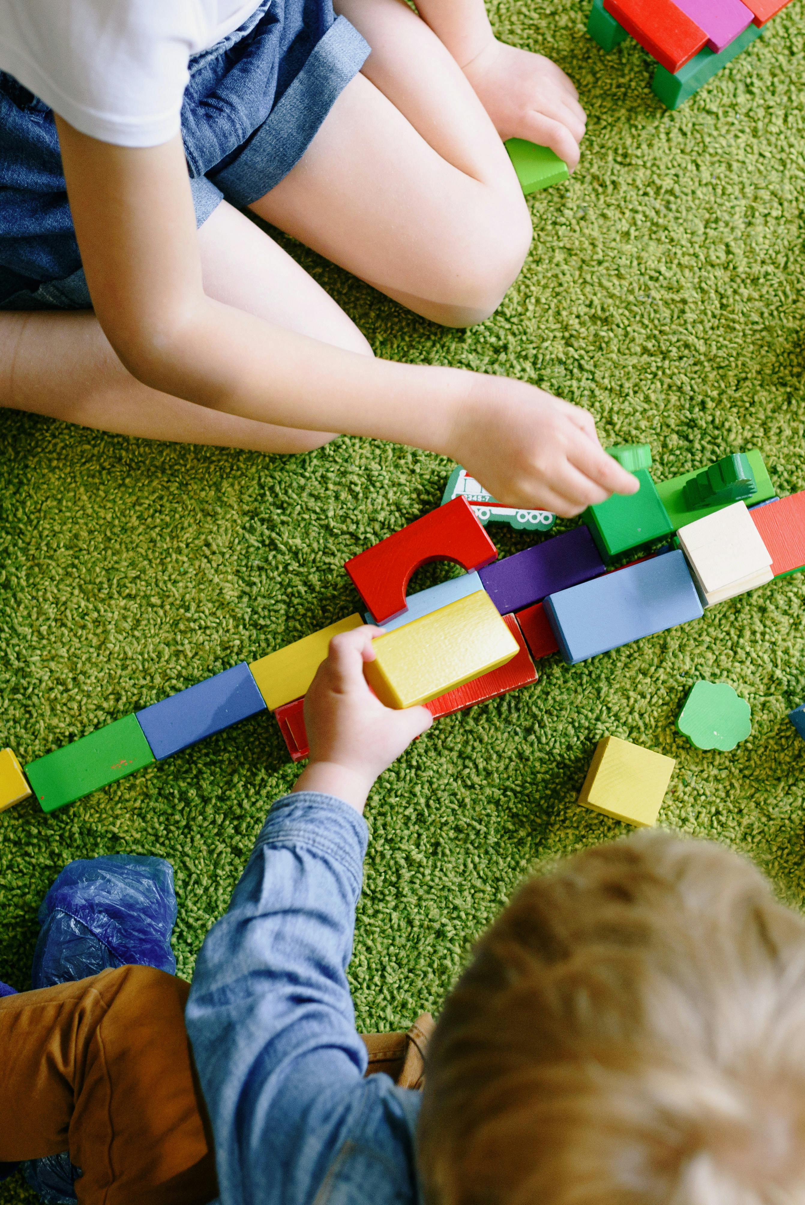 Kinder bauen gemeinsam mit bunten Lego-Steinen beim Lego-Kindergeburtstag