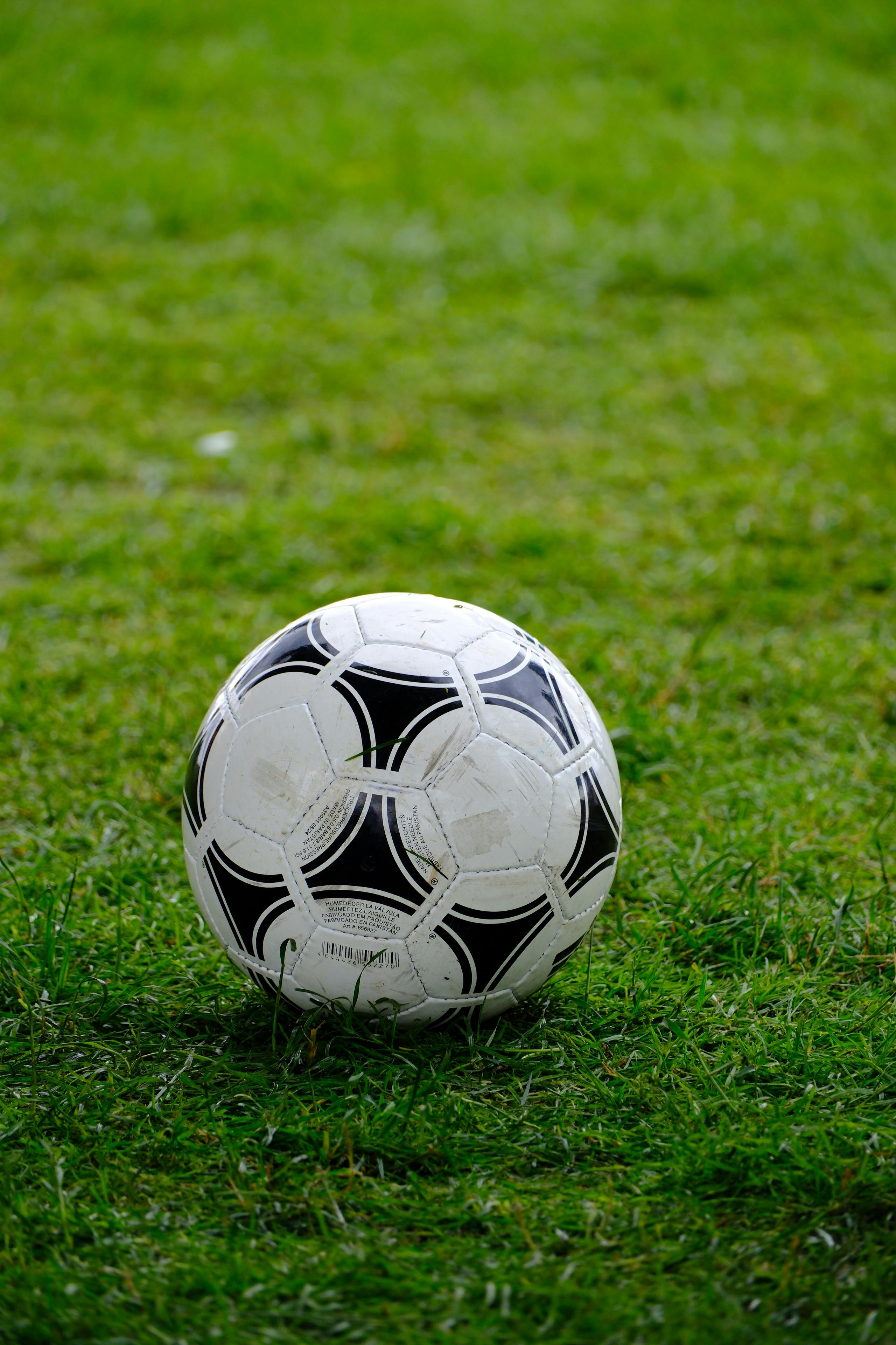 Kinder spielen Fußball beim Fußball-Kindergeburtstag auf dem Rasen