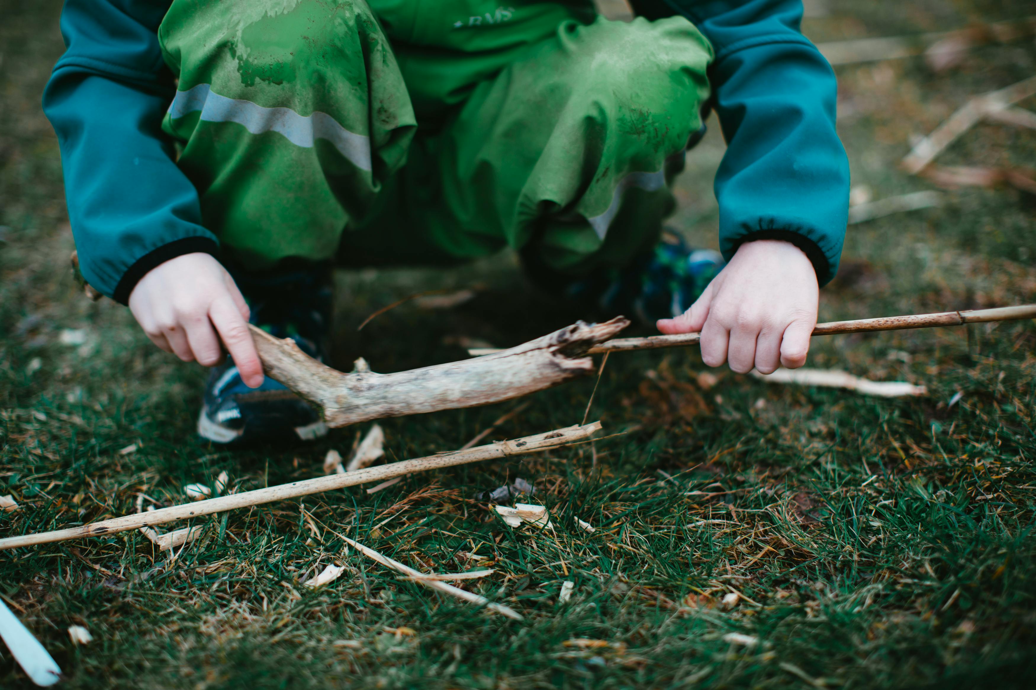 Kinder bauen eine Hütte aus Ästen beim Survival-Kindergeburtstag im Wald