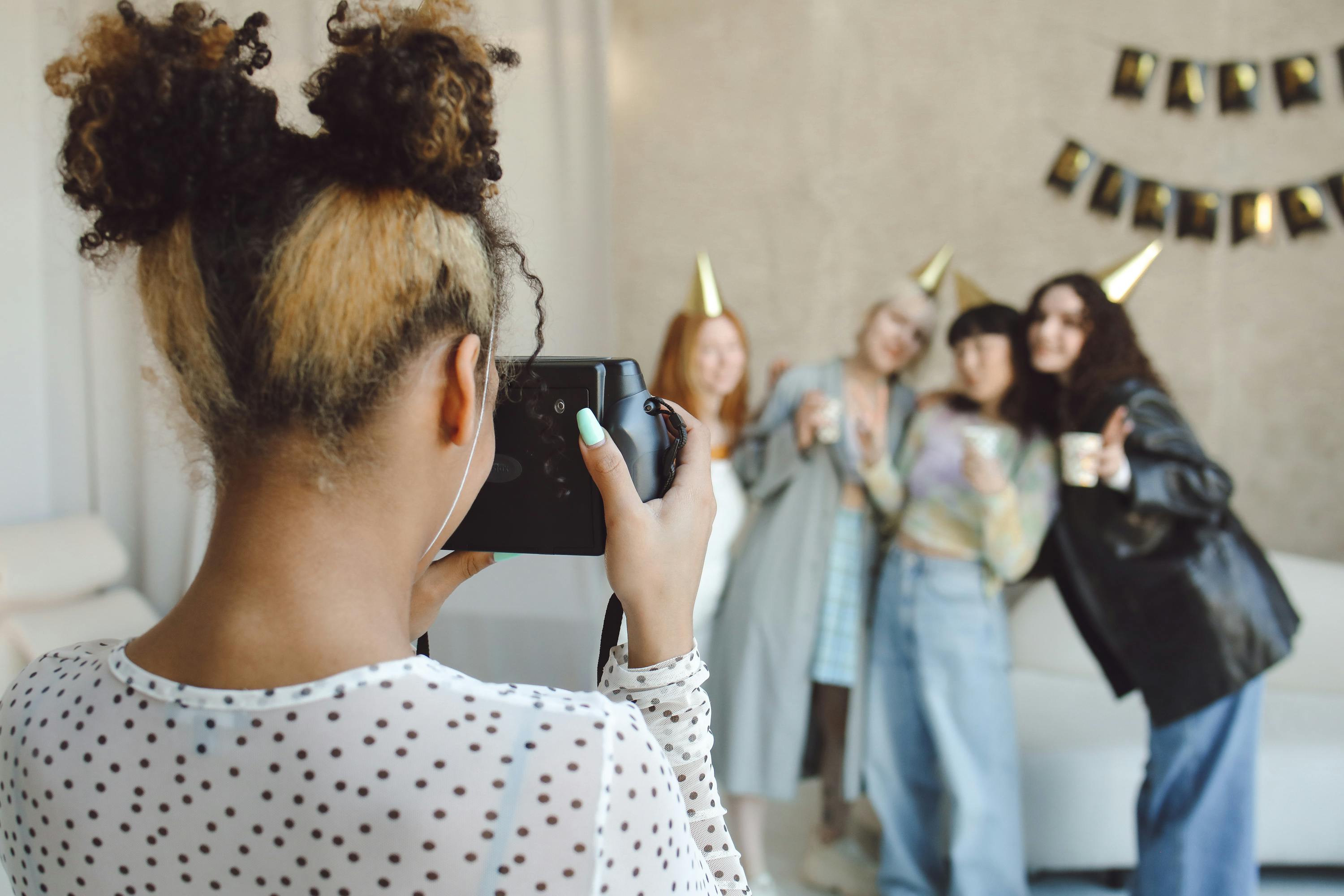 Teenager posieren mit Foto-Requisiten beim Photo-Booth-Geburtstag – Hüte, Brillen und bunte Schilder