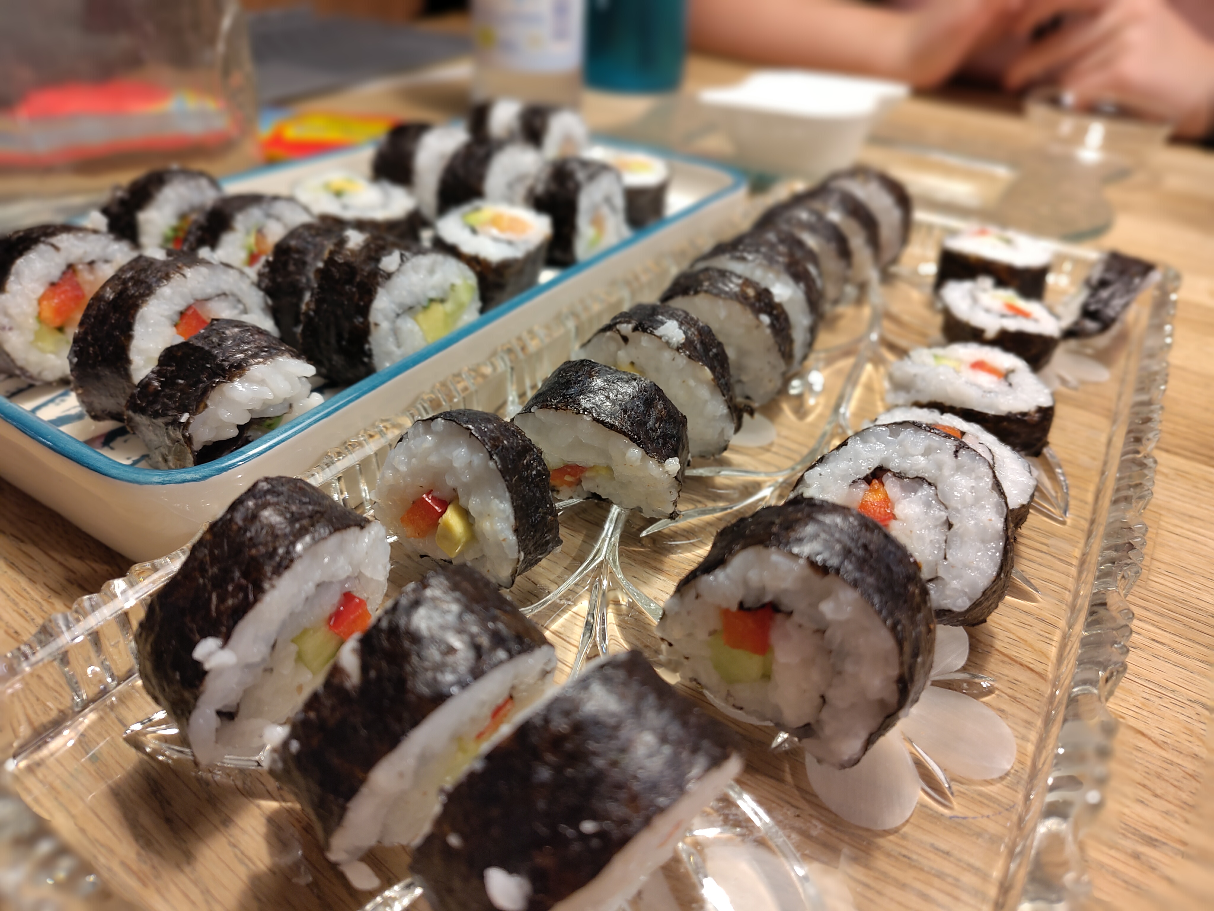 Teenager rollen gemeinsam Sushi beim Kochkurs-Geburtstag – Bambus-Matten, Reis und bunte Zutaten